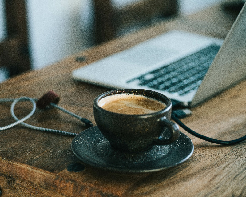 Laptop with a cup of coffee for online therapy with Elisa Lewis